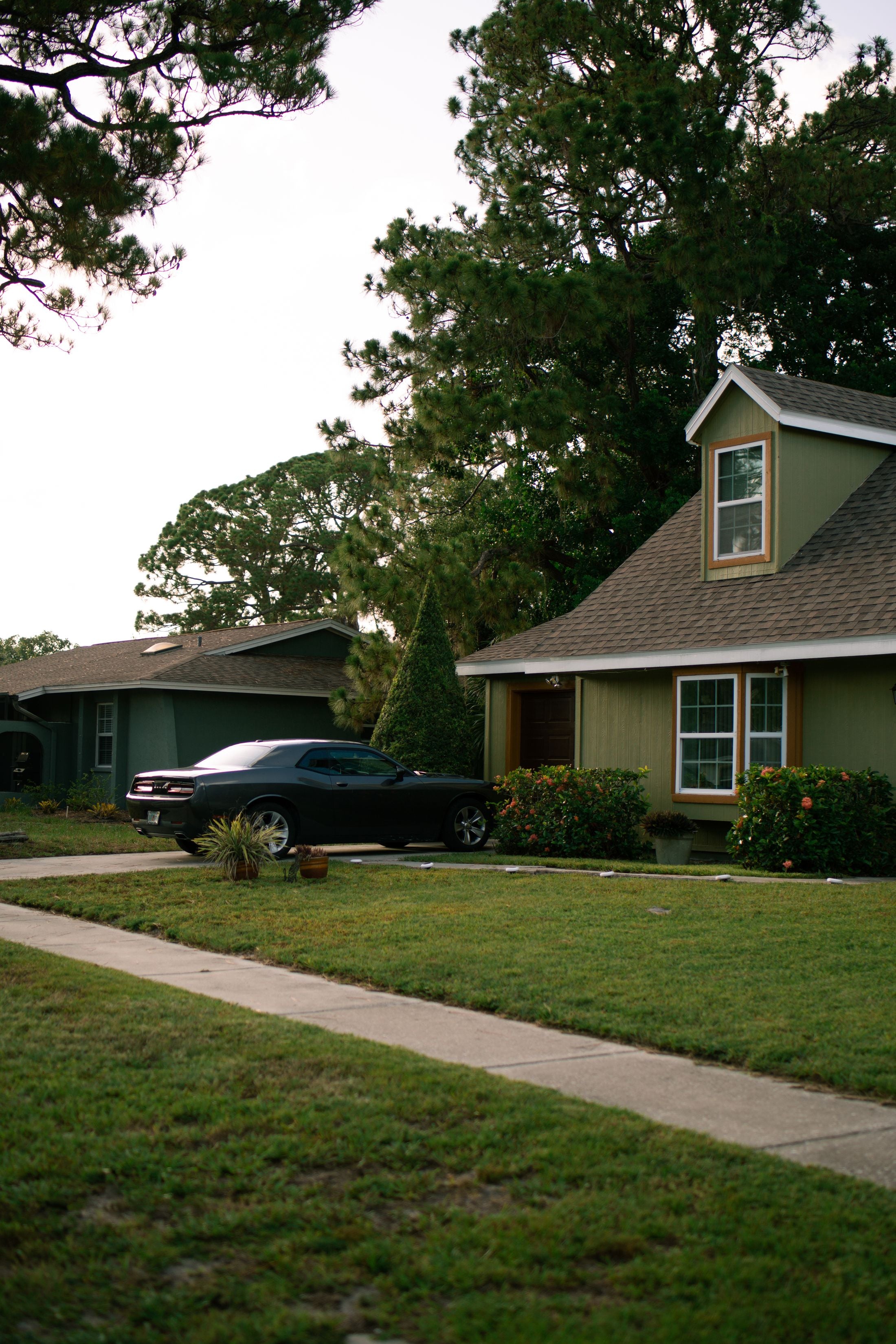 A car parked in a suburban driveway at dusk